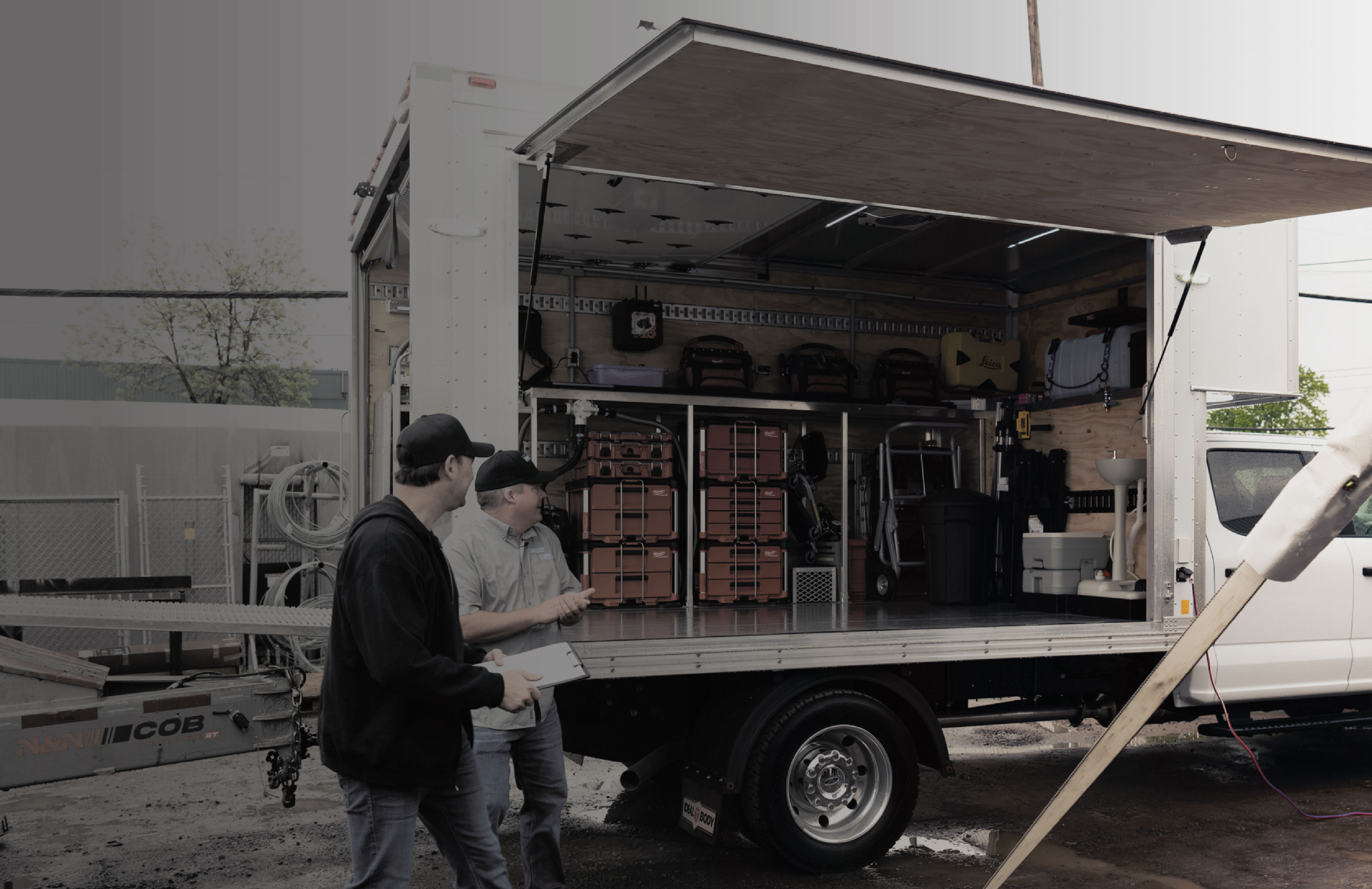Deux professionnels devant le camion-usine UPGRADE ouvert, chargé d'inventaire et d'équipement