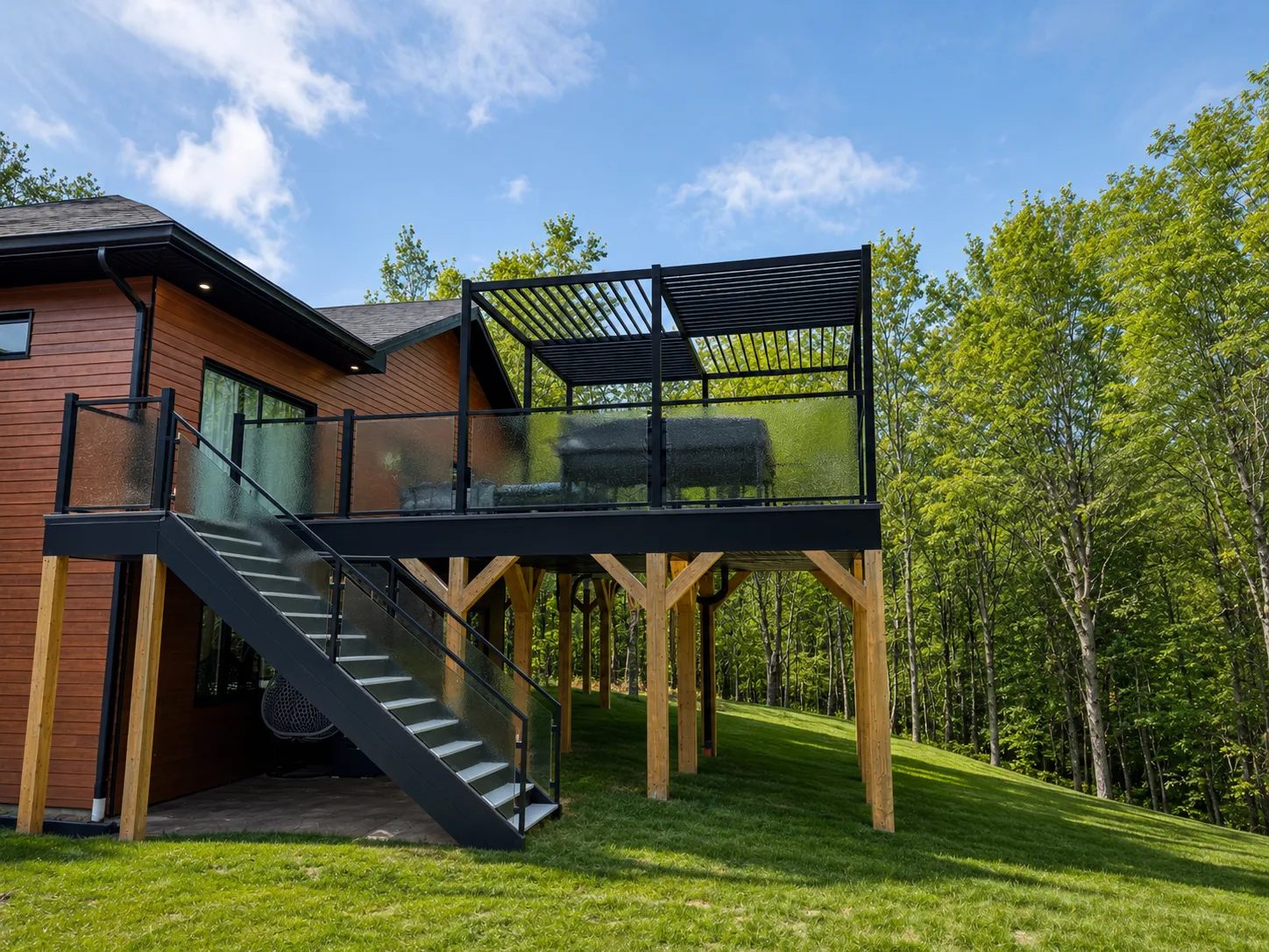 UPergolas noir sur terrasse surélevée, vue d'ensemble avec escalier et maison en bois